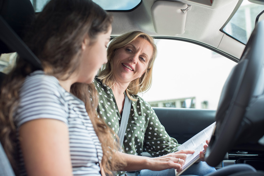 Driving instructor with learner in car